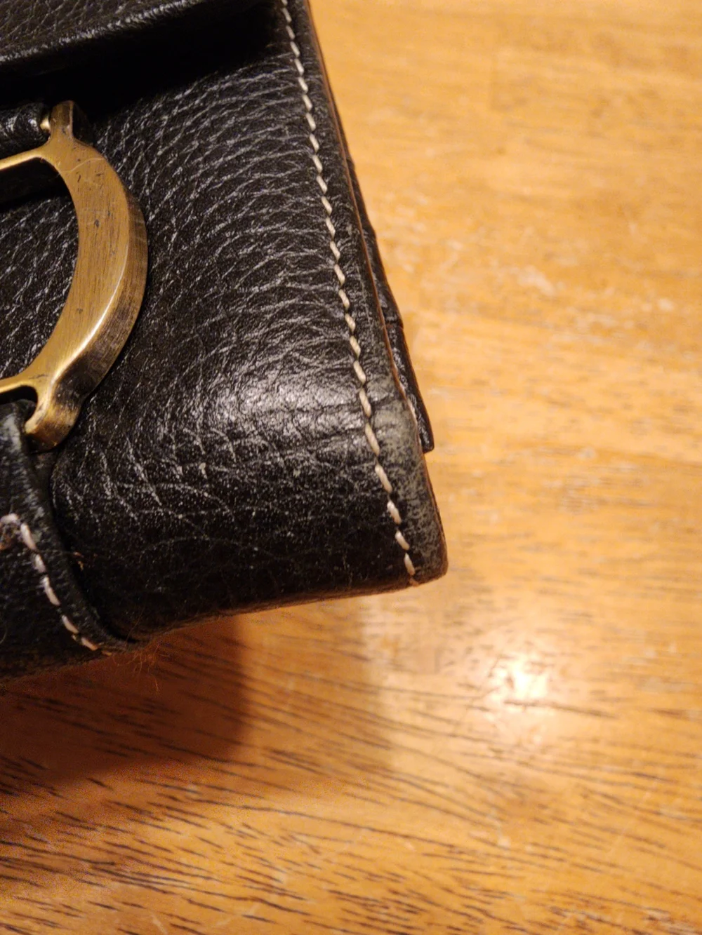 black Christian Dior pebbled leather trifold long wallet featuring gold-tone 